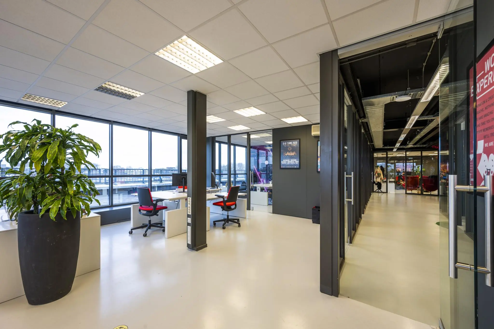 Modern kantoorinterieur aan de Anthony Fokkerweg met glazen wanden, bureaus en een grote plant.
